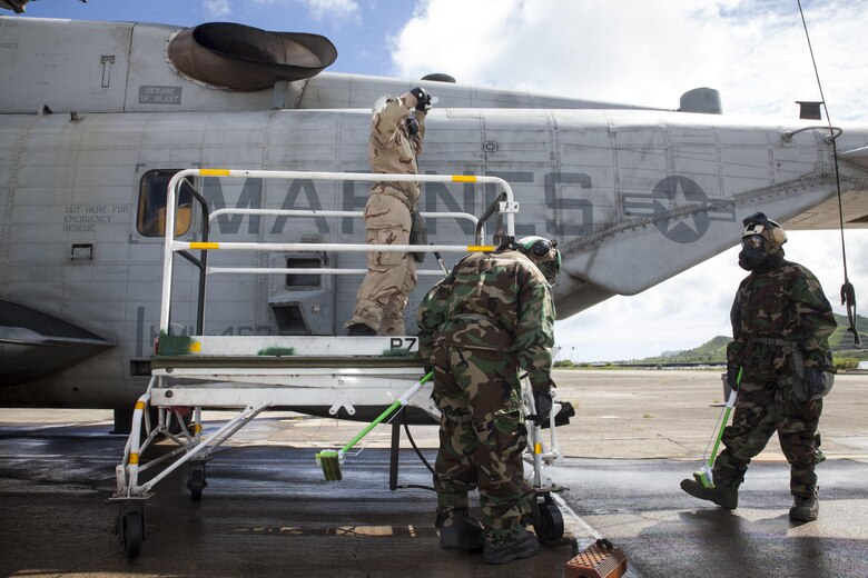 U.S. Marines with Marine Heavy Helicopter Squadron  463, also known as “Pegasus,” Marine Aircraft Group  24, scrub the side of a CH-53E Super Stallion helicopter during  a detailed aircraft decontamination (DECON) exercise, Marine Corps Base Hawaii , Nov. 8, 2017. The DECON exercise instructed Marines on proper techniques and procedures with responding to a chemical, biological, radiological or nuclear contamination on a static helicopter. (U.S. Marine Corps photo by Cpl. Jesus Sepulveda Torres)