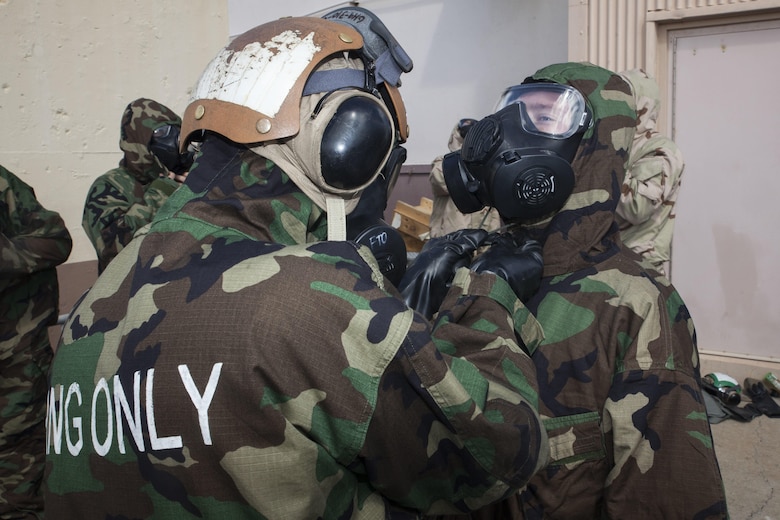 U.S. Marines with Marine Heavy Helicopter Squadron  463, also known as “Pegasus,” Marine Aircraft Group  24, assist each other in donning their mission oriented protective posture  suits prior to a detailed aircraft decontamination (DECON) exercise, Marine Corps Base Hawaii , Nov. 8, 2017. The DECON exercise instructed Marines on proper techniques and procedures with responding to a chemical, biological, radiological or nuclear contamination on a static helicopter. (U.S. Marine Corps photo by Cpl. Jesus Sepulveda Torres)