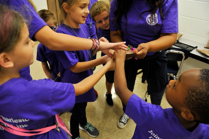 Children feel the vacuum sealed packaging of crackers from a Meals, Ready to Eat package during a youth deployment line at Joint Base Charleston – Weapons Station, S.C., Nov. 4, 2017.