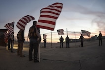 American flags wave against the sunset as members of the Oklahoma Patriot Guard Riders prepare to escort the remains of Marine Corps Pvt. Vernon Paul Keaton November 14, 2017, Will Rogers World Airport, Oklahoma City, Oklahoma.