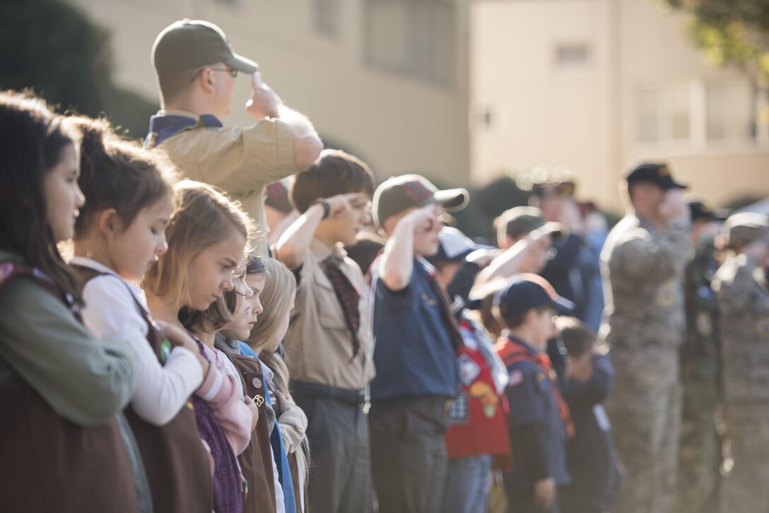 Girl and Boy scouts stand in formation with veterans and service members for the national anthem during a Veterans Day Ceremony, Nov. 10, 2017, at Yokota Air Base, Japan.