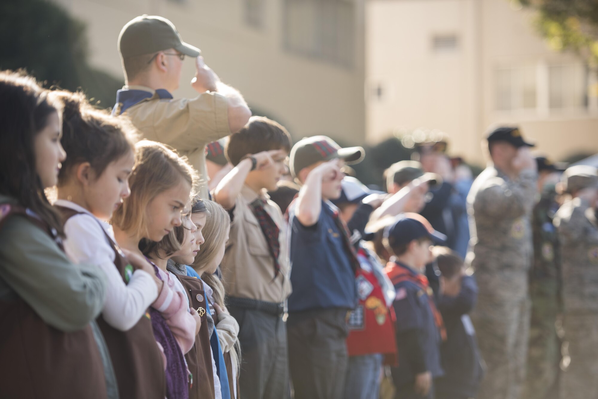 Girl and Boy scouts stand in formation with veterans and service members for the national anthem during a Veterans Day Ceremony, Nov. 10, 2017, at Yokota Air Base, Japan.