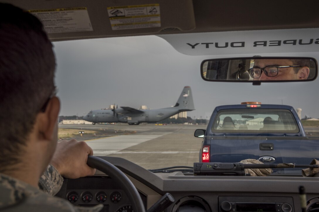 Senior Airman Brendan Kinser, 374th Civil Engineer Squadron pavements and equipment journeyman, waits for a C-130J Super Hercules to take off prior to driving on the flight line, Nov. 15, 2017, at Yokota Air Base, Japan.