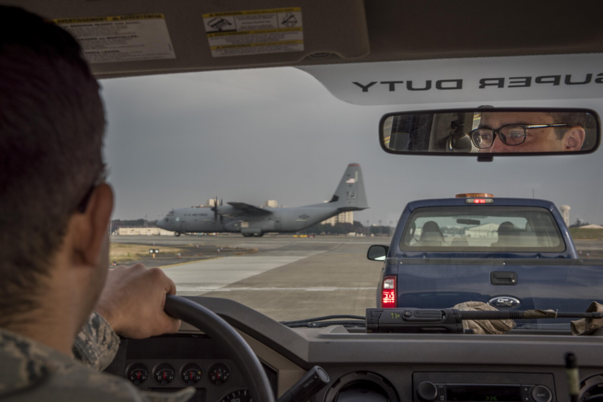 Senior Airman Brendan Kinser, 374th Civil Engineer Squadron pavements and equipment journeyman, waits for a C-130J Super Hercules to take off prior to driving on the flight line, Nov. 15, 2017, at Yokota Air Base, Japan.