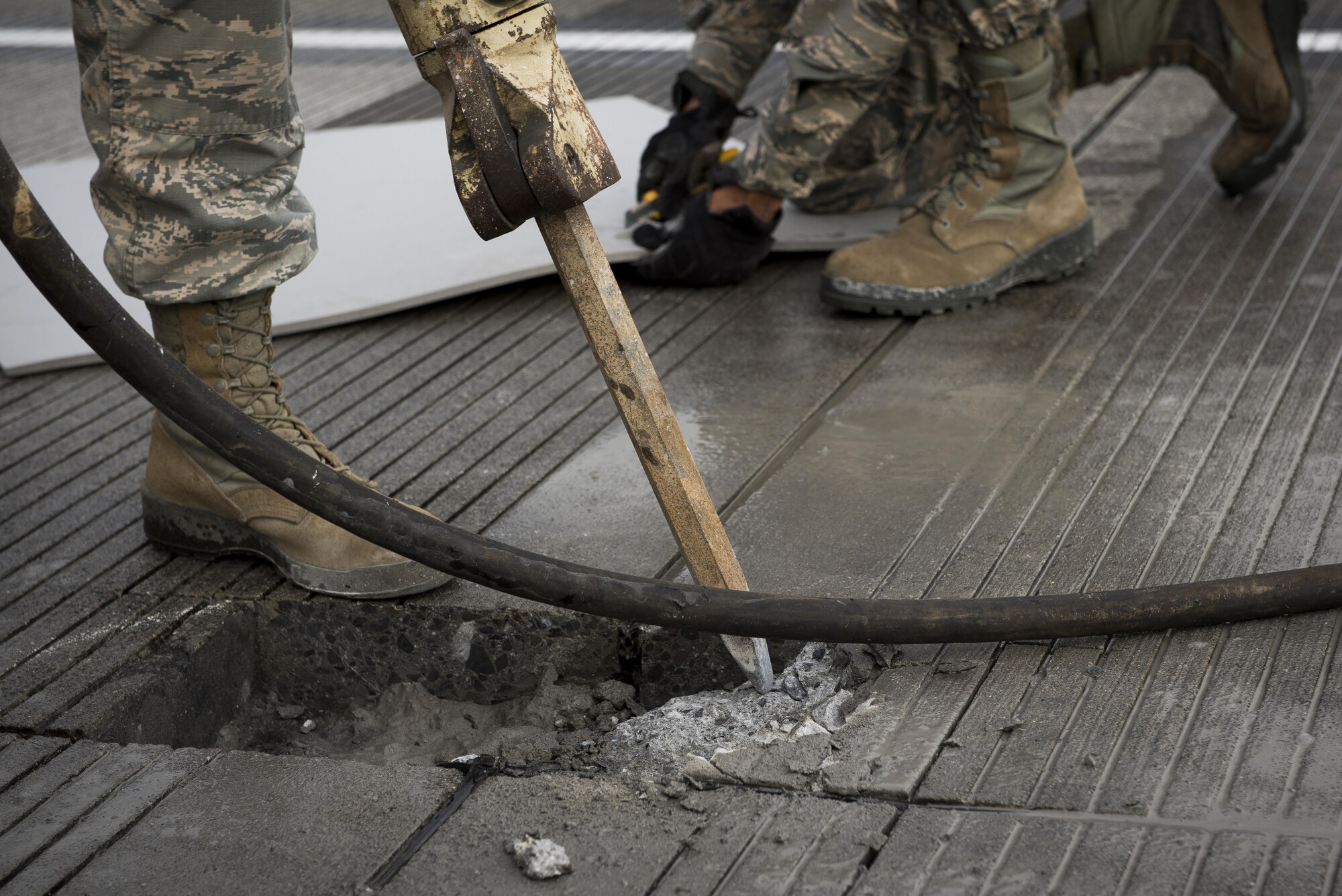 Airman 1st Class Taj Zook, 374th Civil Engineer Squadron pavements and equipment journeyman, operates a jackhammer to remove degraded concrete from the runway, Nov. 15, 2017, at Yokota Air Base, Japan.