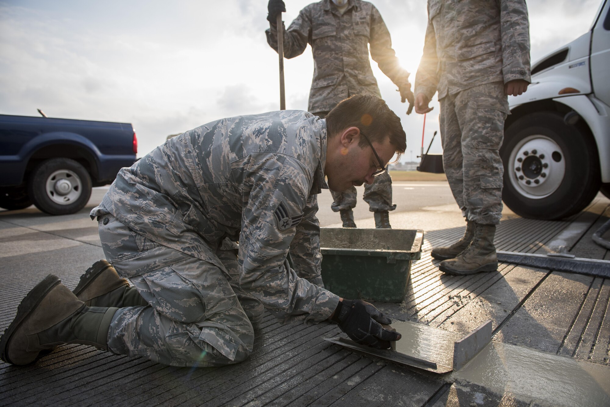 Senior Airman Brendan Kinser, 374th Civil Engineer Squadron pavements and equipment journeyman, performs the finishing touches to freshly placed concrete on the runway, Nov. 15, 2017, at Yokota Air Base, Japan.