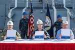 Ingalls Shipbuilding delivered the guided missile destroyer Ralph Johnson (DDG 114) to the U.S. Navy today. Signing the DD 250 document are (left to right) Cmdr. Jason P. Patterson, the ship’s prospective commanding officer; Cmdr. Scott Williams, program manager representative for Supervisor of Shipbuilding Gulf Coast; and Freddie Joe O’Brien, Ingalls’ DDG 114 ship program manager.