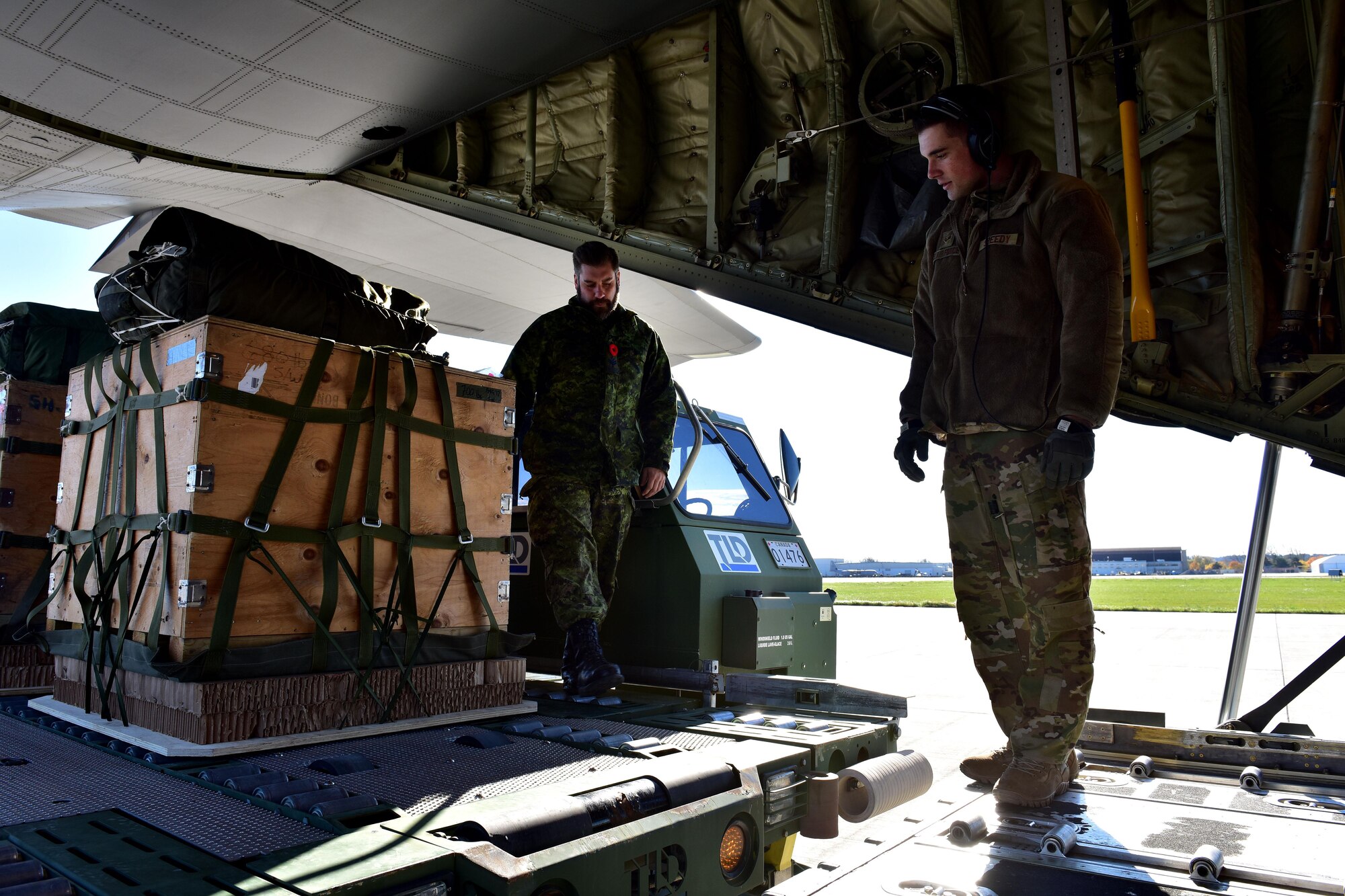 Senior Airman Jordon Speedy, 41st Airlift Squadron loadmaster, and Royal Canadian Air Force  Sergeant Perter Larue, 2 Air Movement Squadron NCO in Charge of tactical operations, load  Container Delivery System bundles on a Little Rock AFB C-130J at Canadian Forces base Trenton in Ontario, Canada, Nov. 6, 2017. The size and weight of the CDS's vary to simulate different loads the aircraft might carry. (U.S. Air Force photo by SSgt Jeremy McGuffin)