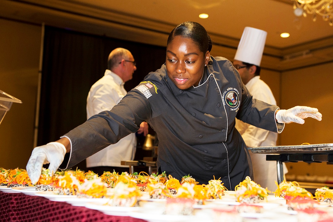 A  Petty Officer prepares a dish during the USO Salute to Military Chefs dinner.
