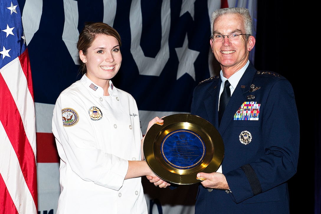 Air Force Gen. Paul J. Selva presents a best chef award to a petty officer .