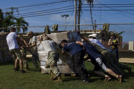 Soldiers and Volunteers Push Pallet of Grocery Boxes