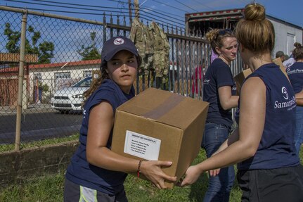 Volunteer Passes Box of Groceries