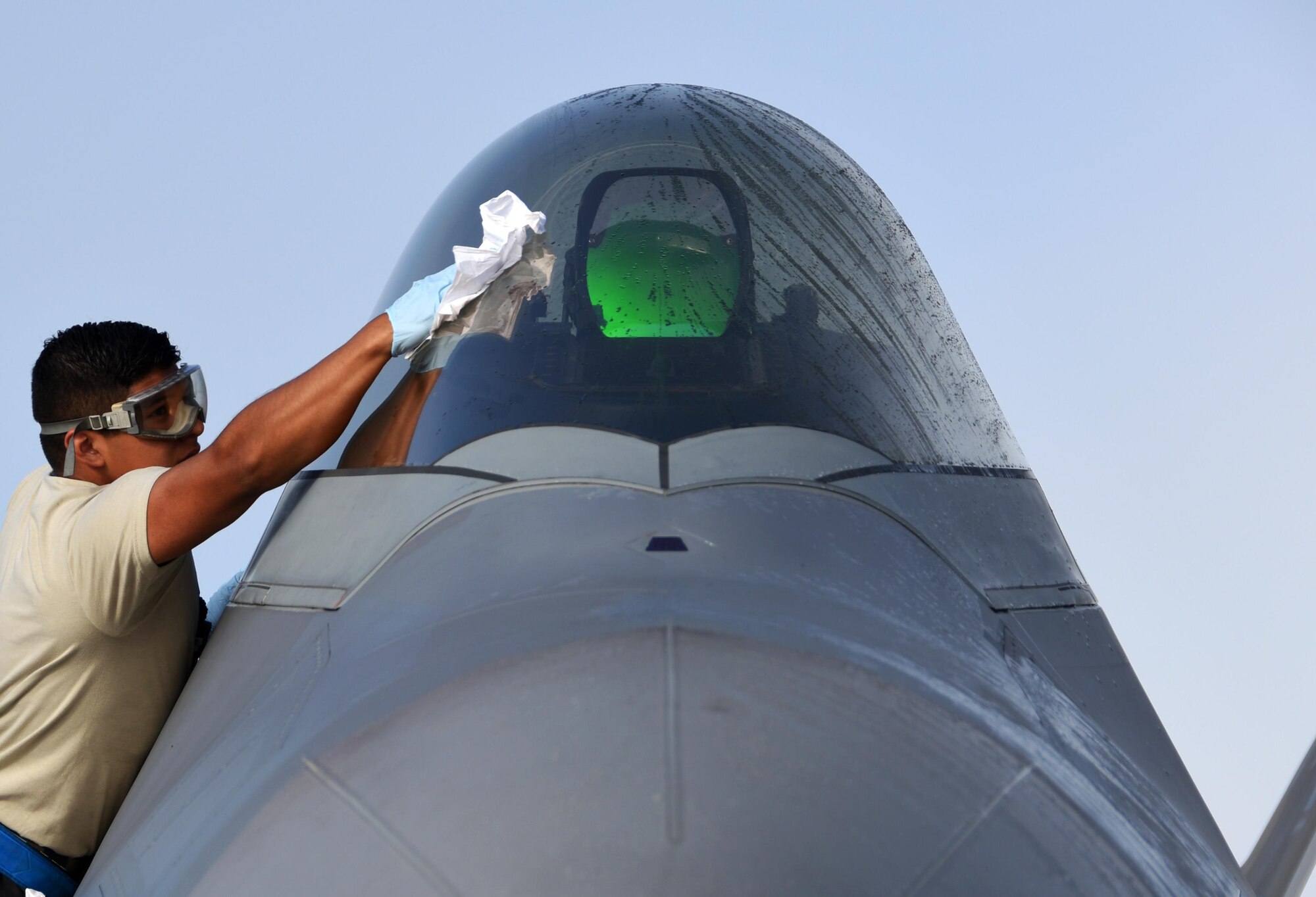 U.S. Air Force Airman 1st Class Andrew Alcozer, 3rd Aircraft Maintenance Squadron crew chief, cleans the canopy of a 525th Fighter Squadron F-22 Raptor at Tyndall Air Force Base, Fla., Nov. 7, 2017. Tyndall AFB is the host location for Checkered Flag 18-1, a large-scale aerial exercise designed to integrate fourth and fifth-generation airframes while providing a platform for maintenance teams to be evaluated. (U.S. Air Force photo by Airman 1st Class Isaiah J. Soliz/Released)