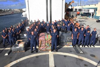 The crew of the Coast Guard Cutter Spencer stands next to approximately 10 tons of seized drugs