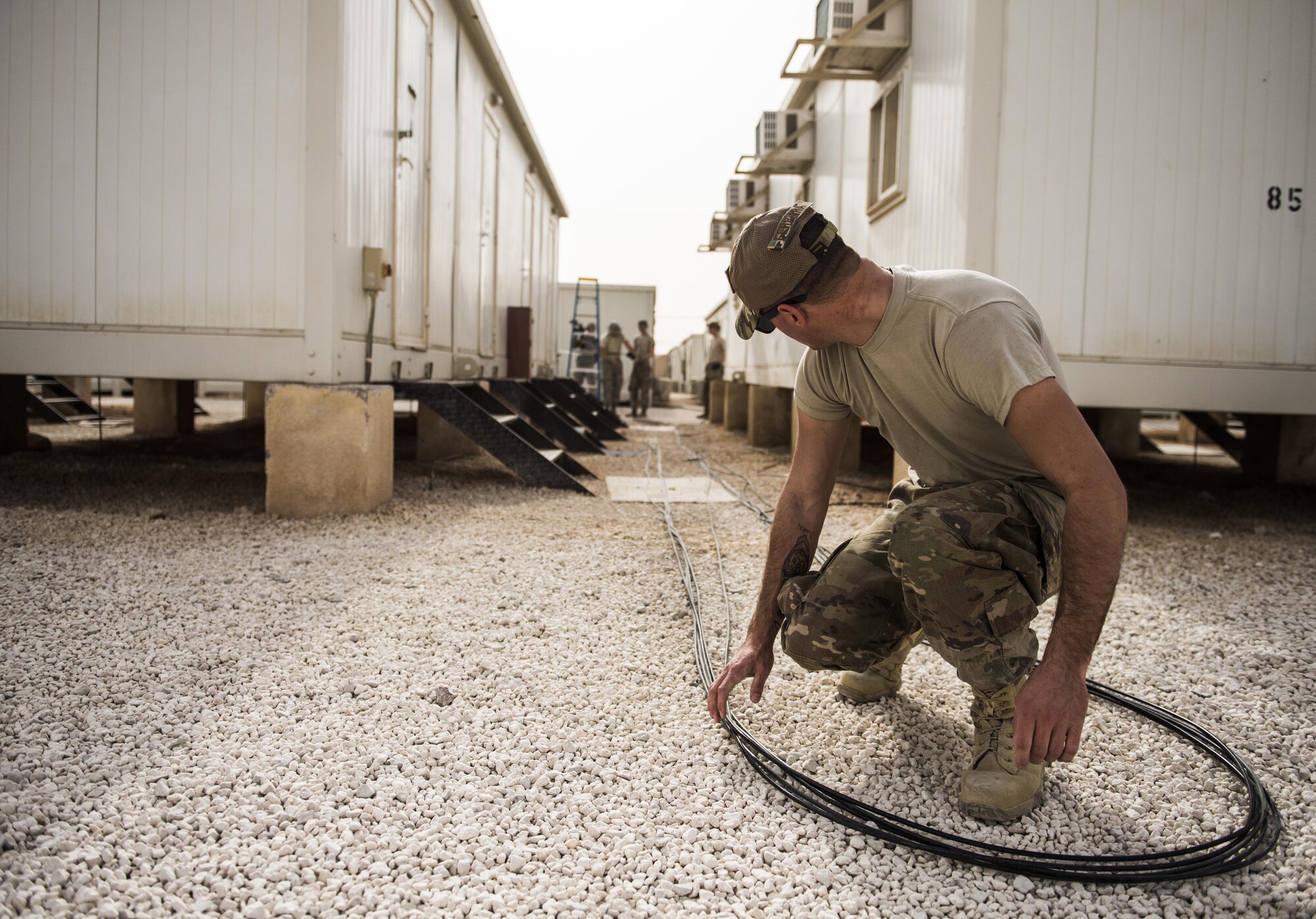 SrA Jacob Ferreira, assigned to the 332nd Expeditionary Communications Squadron, positions copper wire for installation as part of a base-wide wireless internet improvement project Nov. 13, 2017 in Southwest Asia. The 332nd ECS has made rapid improvements to base internet connectivity in recent months, providing deployed service members with a more reliable, flexible connection to home. (U.S. Air Force by Senior Airman Joshua Kleinholz)