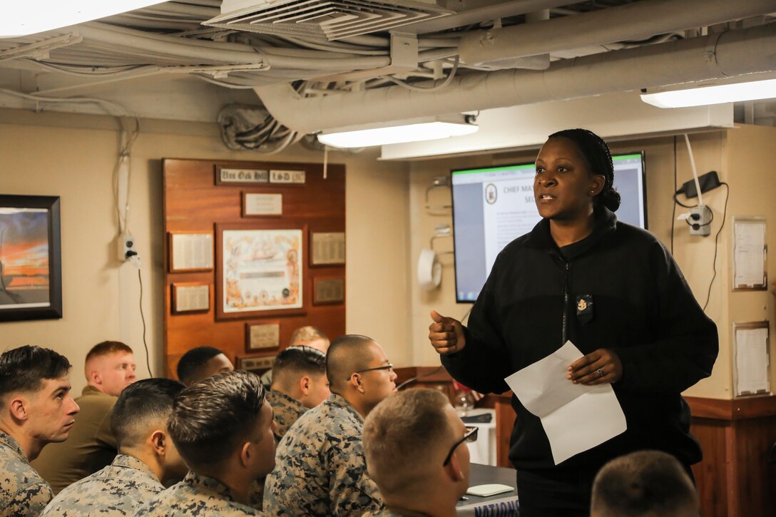 A U.S. Sailor assigned to the dock landing ship USS Oak Hill (LSD 51) delivers part of a welcome aboard brief to U.S. Marines and Sailors with Fox Company, Battalion Landing Team, 2nd Battalion, 6th Marine Regiment, as part of Combined Composite Training Unit Exercise (COMPTUEX) while underway Nov. 15, 2017. COMPTUEX allows all elements of the Marine Air Ground Task Force (MAGTF) to join and train in realistic scenarios so the MEU as a whole can meet its Predeployment Training Program objectives prior to an upcoming deployment at sea. (U.S. Marine Corps photo by Staff Sgt. Dengrier M. Baez)