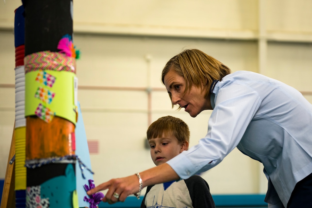 Col. Jennifer Short, 23d Wing commander, talks with her son, Jacob, about one of the science fair projects during the 23d Civil Engineer Squadron Recycling Science Fair, Nov. 15, 2017, at Moody Air Force Base, Ga. The 23d CES partnered with Moody's Youth Programs for America Recycles Day. The event consisted of a fashion show, as well as a recycle science fair. It was designed to help foster more interest in recycling, to increase recycling on base and promote less solid waste to landfills. (U.S. Air Force photo by Airman 1st Class Erick Requadt)