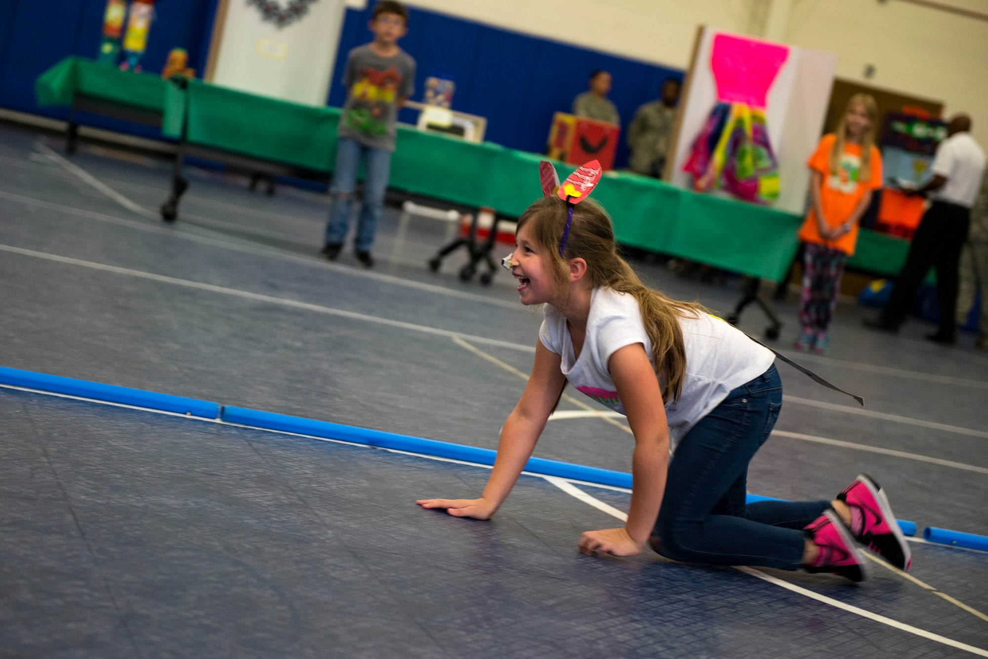 A fashion show participant dressed as a pig crawls down the catwalk during the 23d Civil Engineer Squadron Recycling Science Fair, Nov. 15, 2017, at Moody Air Force Base, Ga. The 23d CES partnered with Moody's Youth Programs for America Recycles Day. The event consisted of a fashion show, where everything was made out of recycled materials. It was designed to help foster more interest in recycling, to increase recycling on base and promote less solid waste to landfills. (U.S. Air Force photo by Airman 1st Class Erick Requadt)