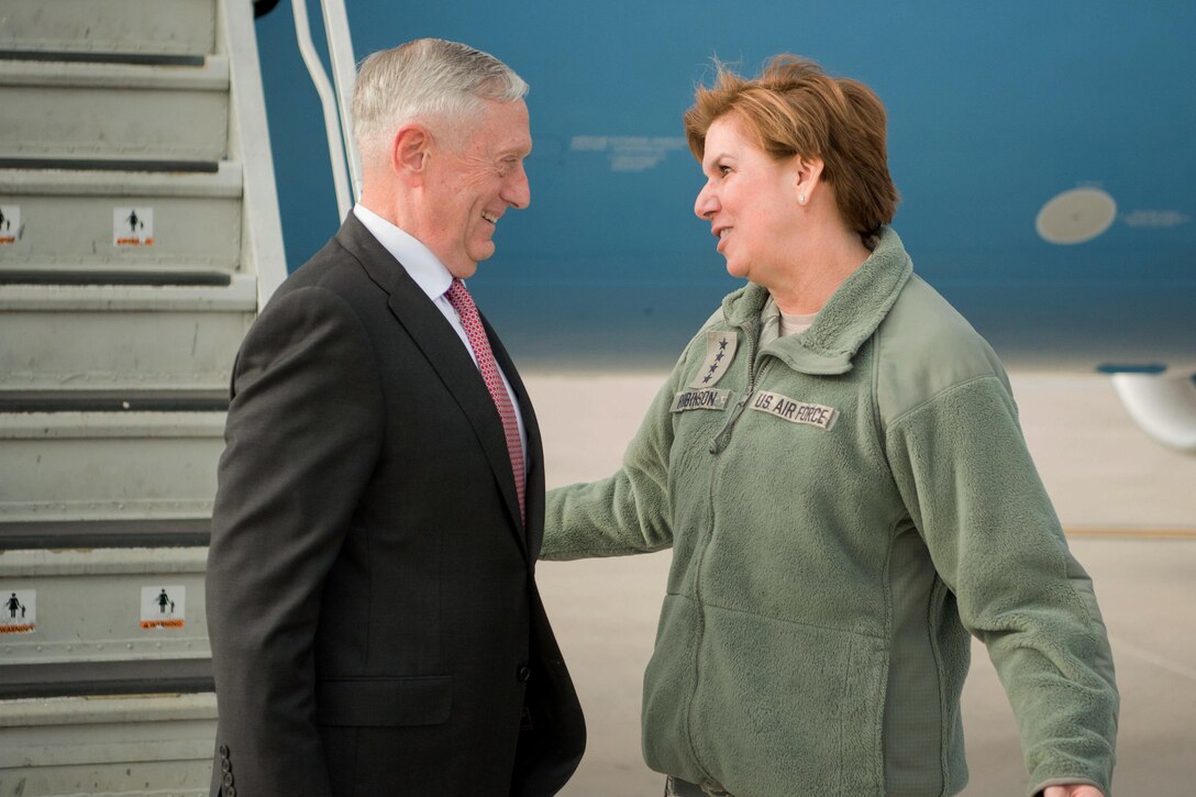 Defense Secretary Jim Mattis talks with Northcom's commander at the steps of an aircraft.