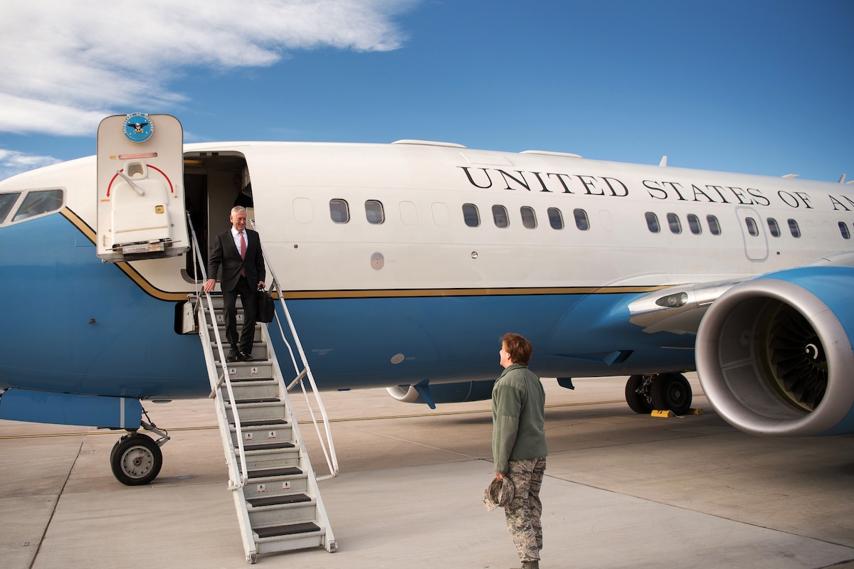Defense Secretary Jim Mattis walks down the steps off an aircraft.