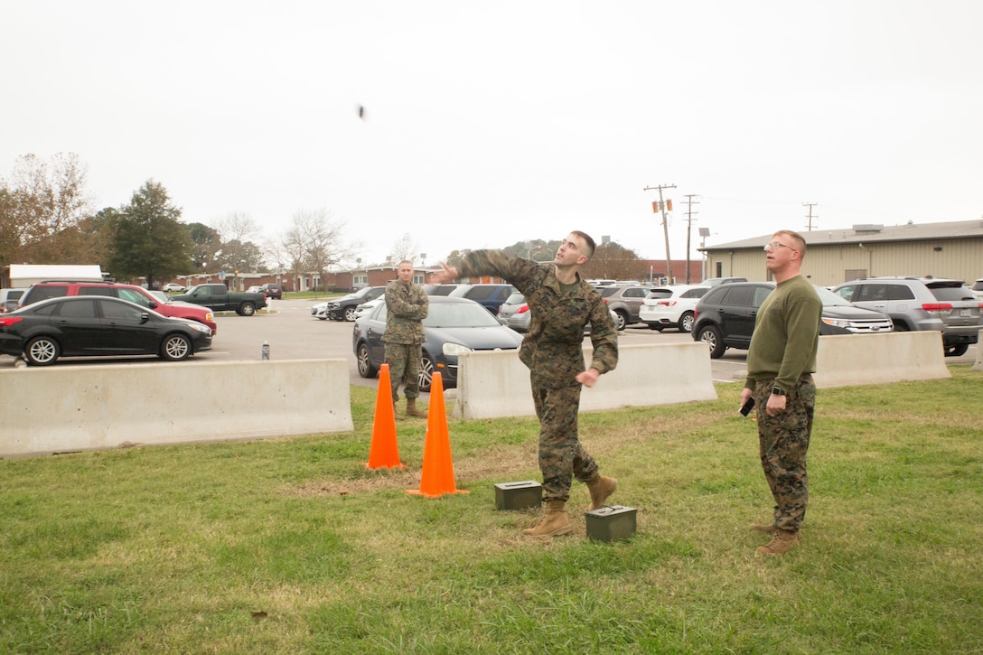 Sgt. Mark Tuggle, mass communicator, communication strategies and operations office, U.S. Marine Corps Forces Command, throws a 5-pound dummy grenade during the “maneuver under fire” event of the Combat Fitness Test at the Headquarters and Service Battalion building, at Camp Allen, Norfolk, Va., Nov. 15. Marines were required to hit a target area 22.5 yards away to receive a five second deduction on their overall time. (Official Marine Corps photo by Chris Jones/Released)