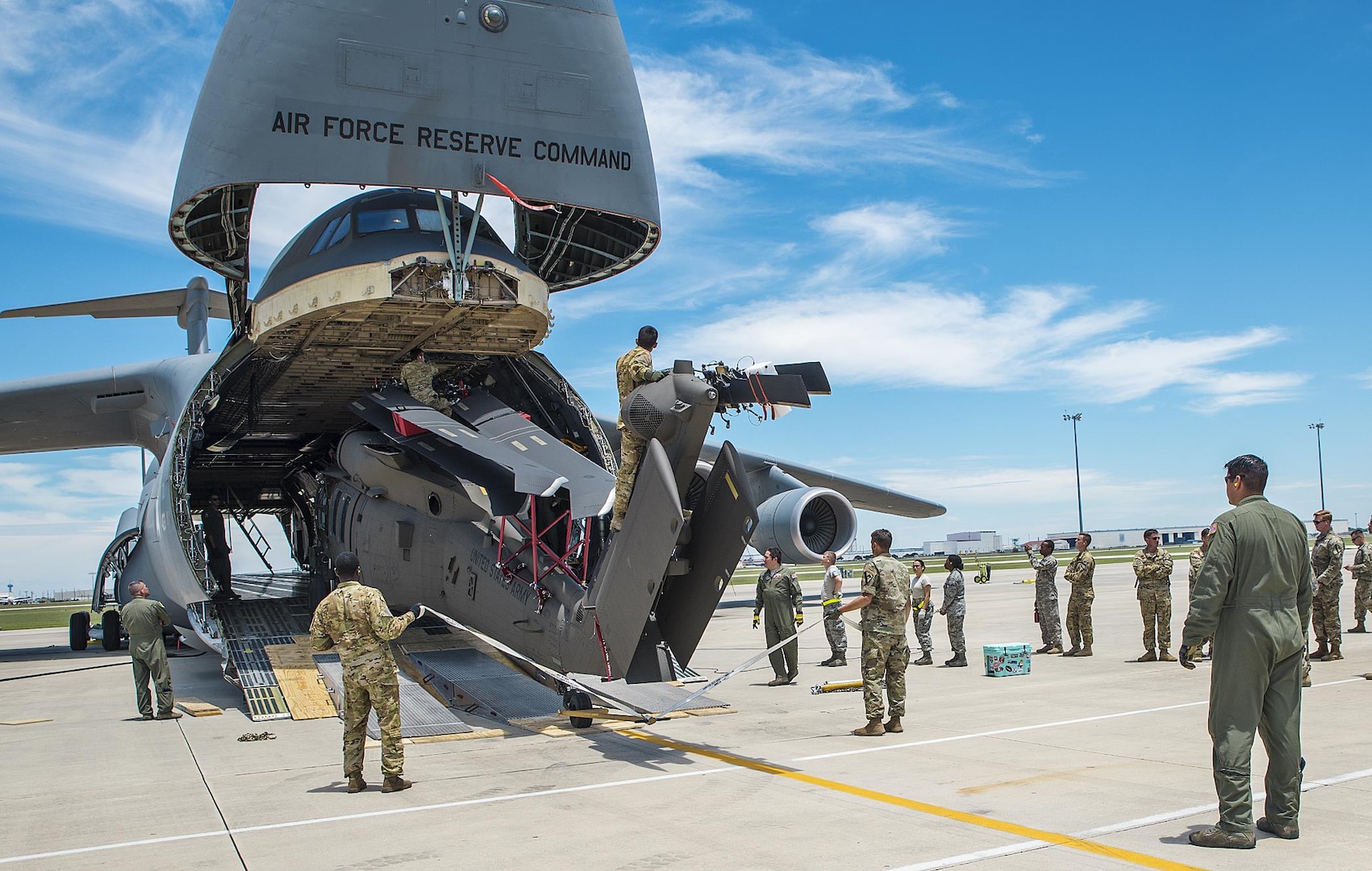 Soldiers from the 1st Air Cavalry Brigade, 1st Cavalry Division Ft. Hood, Texas and Airmen from the 26th and 74th Aerial Port Squadrons begin loading a UH-60 Black Hawk helicopter into the cargo hold of a C-5M Super Galaxy aircraft June 22, 2017 at Joint Base San Antonio-Lackland.