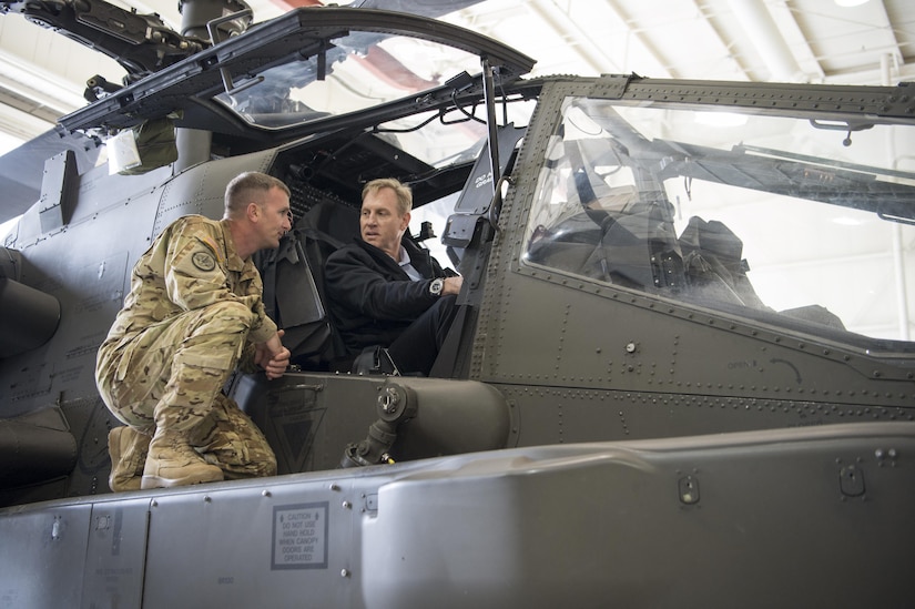 Deputy Defense Secretary Pat Shanahan speaks with a soldier while seated in a helicopter