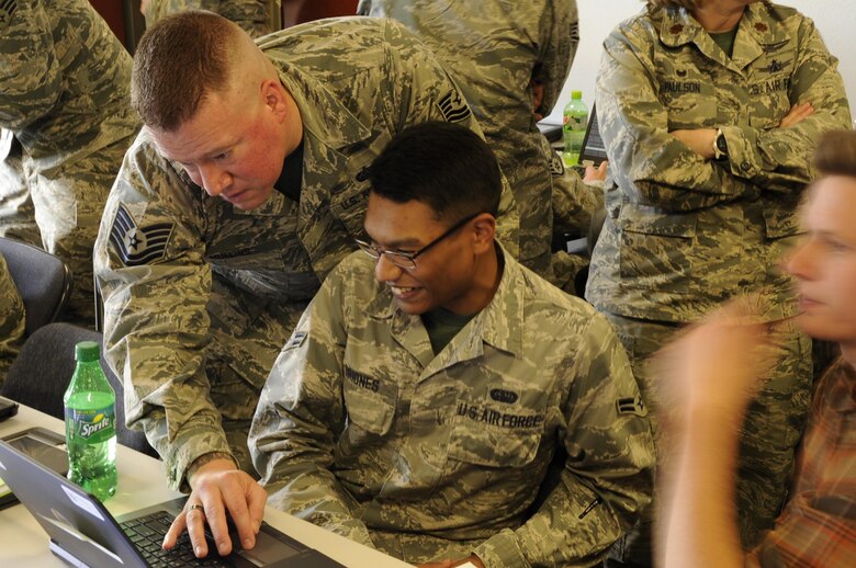 Tech. Sgt. Noah Mullins, assists Airman 1st Class Vincent Briones, both assigned to the 302nd Communications Flight, with computer coding during a "Capture The Flag" cyber operations challenge at Peterson Air Force Base, Colo., Nov. 4, 2017.  Members of the 302nd CF took part in the "Capture the Flag" cyber operations challenge during the November Unit Training Assembly, which aimed to test their ability to identify and respond to cyber threats in a simulated environment. (U.S. Air Force photo/1st Lt. Stephen J. Collier)