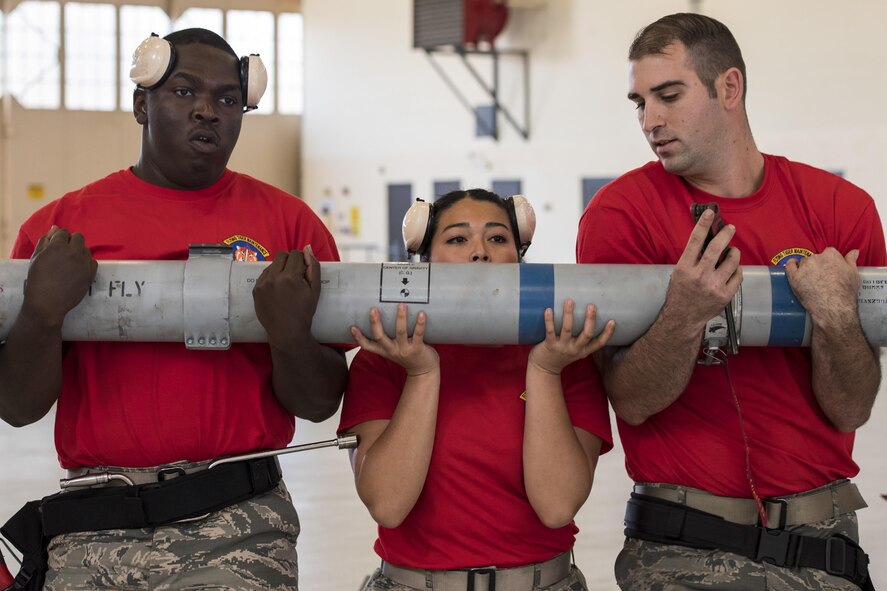 The 75th Aircraft Maintenance Unit (AMU) load crew carries an inert AIM-9 air-to-air missile during a weapons load competition, Nov. 16, 2017, at Moody Air Force Base, Ga. The 74th AMU won the competition this quarter, defeating the 75th AMU. Every quarter, load crews from the 74th and 75th AMUs compete and are judged based on dress and appearance, a knowledge exam and loading various munitions to determine the quickest and most efficient load crew. (U.S. Air Force photo by Senior Airman Janiqua P. Robinson)