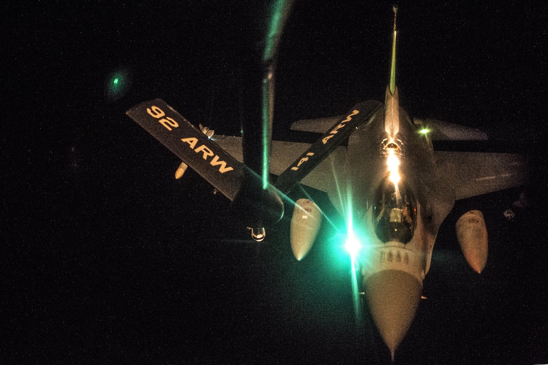 An aircraft receives fuel at night in flight.