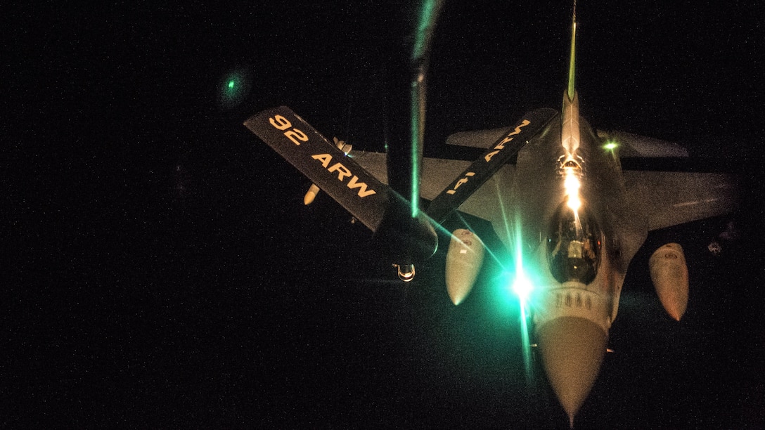 An aircraft receives fuel at night in flight.