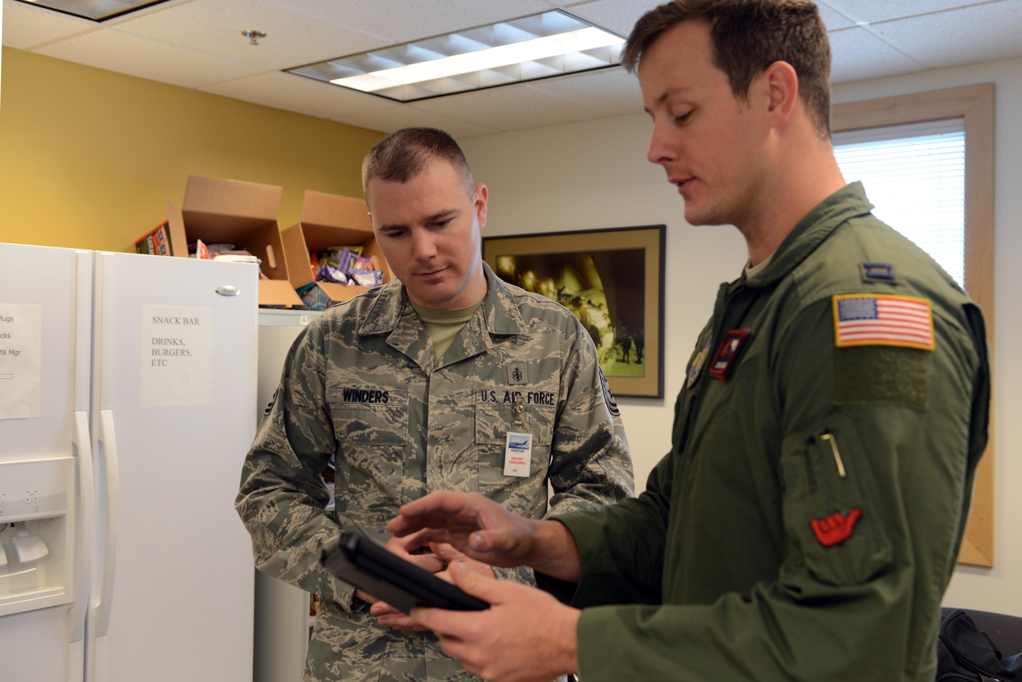 Air Force Capt. John Harris (right), 3rd Operations Support Squadron C-17 pilot and air-refueling schedule manager, explains the route Tech. Sgt. Andrew Winders, 673d Medical Group Inpatient multipurpose unit shift supervisor, will take in the C-17 flight simulator at Joint Base Elmendorf-Richardson, Alaska, Nov. 9, 2017. Two Levitow award recipients were given the opportunity to use the 3rd OSS C-17 flight simulator as a gesture of congratulations.