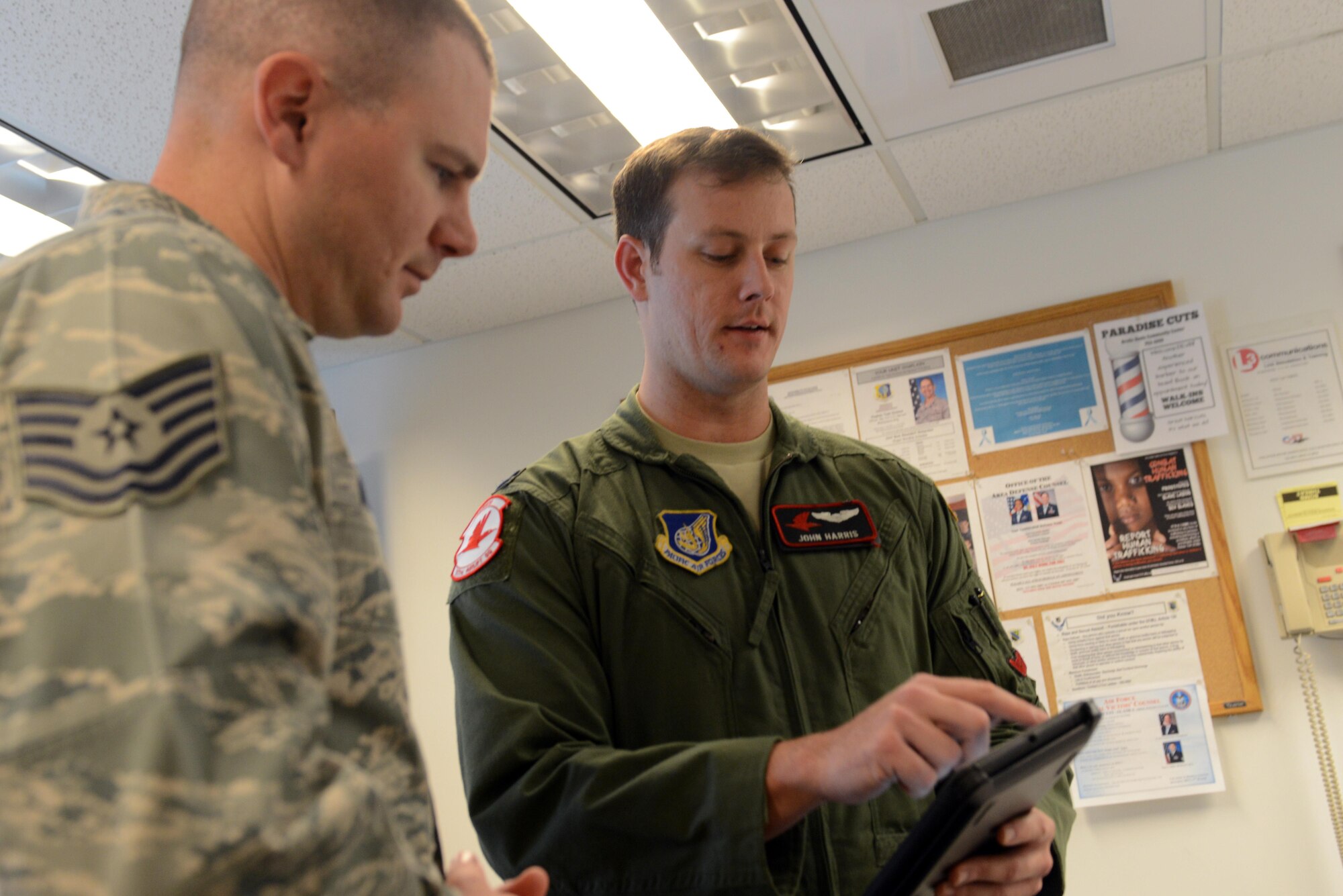 Air Force Capt. John Harris (right), 3rd Operations Support Squadron C-17 pilot and air-refueling schedule manager, explains the route Tech. Sgt. Andrew Winders, 673d Medical Group Inpatient multipurpose unit shift supervisor, will take in the C-17 flight simulator at Joint Base Elmendorf-Richardson, Alaska, Nov. 9, 2017. Two Levitow award recipients were given the opportunity to use the 3rd OSS C-17 flight simulator as a gesture of congratulations.