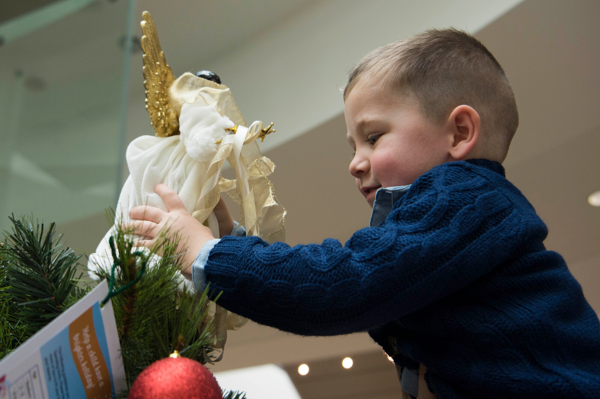 Lincoln Glascock, son of Master Sergeant Jerry Glascock, 21st Operational Weather Squadron First Sergeant, puts the angel on the Angel Tree at Ramstein Air Base, Germany, Nov. 14, 2017. The Angel Tree is an event hosted by the Kaiserslautern Military Community First Sergeant’s Council, where members can give monetary donations to families in need in the KMC. The event will be held from Nov. 14, 2017 – Jan. 1, 2018.