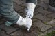 A U.S. Airman assigned to the 86th Comptroller Squadron uses a tool to remove weeds from in between sidewalk tiles on Ramstein Air Base, Nov. 14, 2017. Airman participate in base clean up twice year.