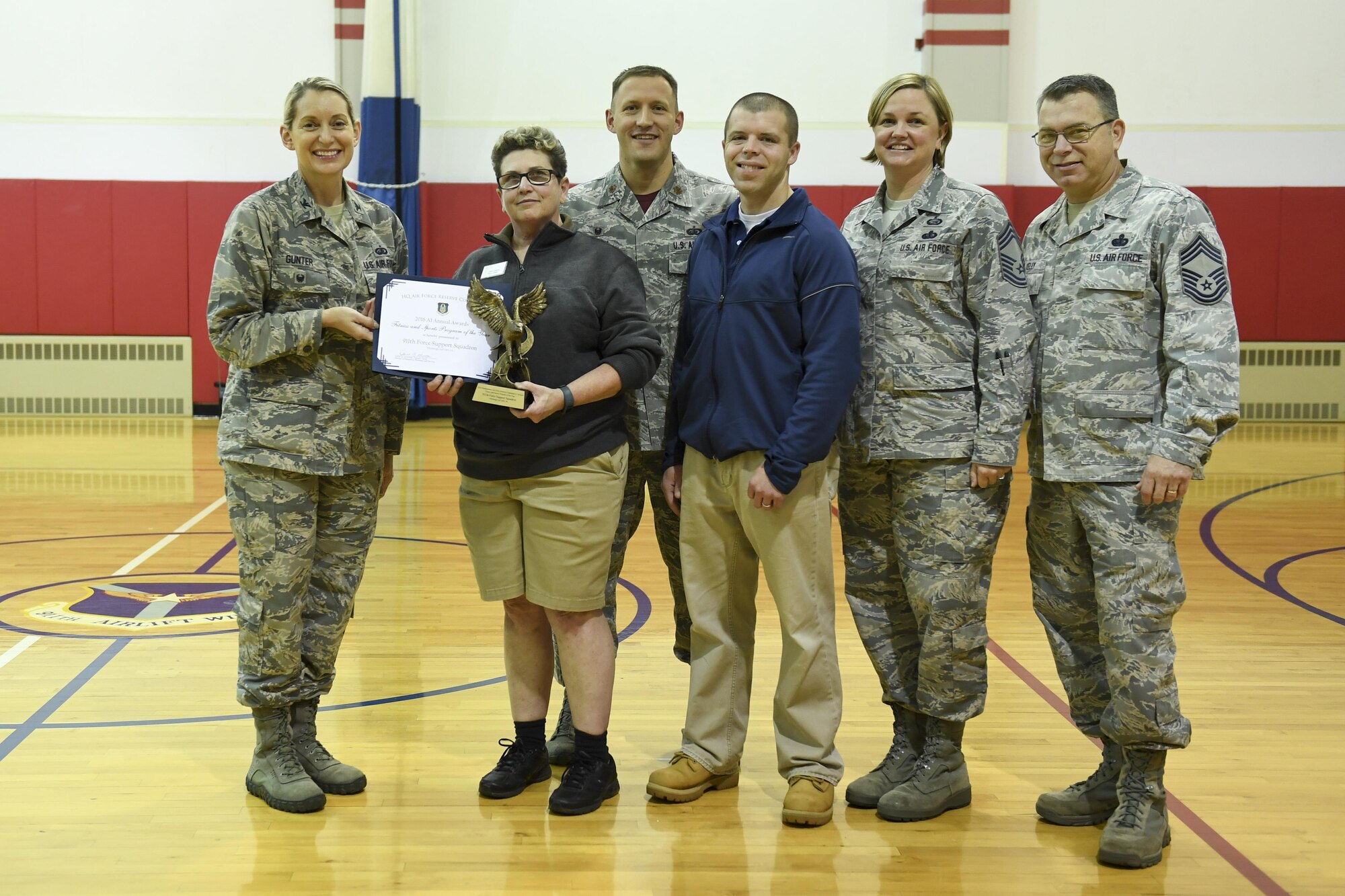 Tamra Davis, director of the 911th Airlift Wing Fitness Center, accepts an award from Col. Anne Gunter, director of manpower, personnel and services, at Headquarters Air Force Reserve Command, recognizing the 911th AW fitness program as the 2016 A1 Fitness and Sports Program of the Year at the 911th AW Fitness Center, November 5, 2017. They were joined by Maj. Brett Dorey, commander of the 911th Airlift Wing Force Support Squadron, Chief Master Sgt. Kelly Kruger, Air Force Reserve Command A1 Superintendent/ 3F000 Major Command Functional Manager, and Chief Master Sgt. Dan Kelly, Air Force Reserve Command 3F100 Major Command Functional Manager.