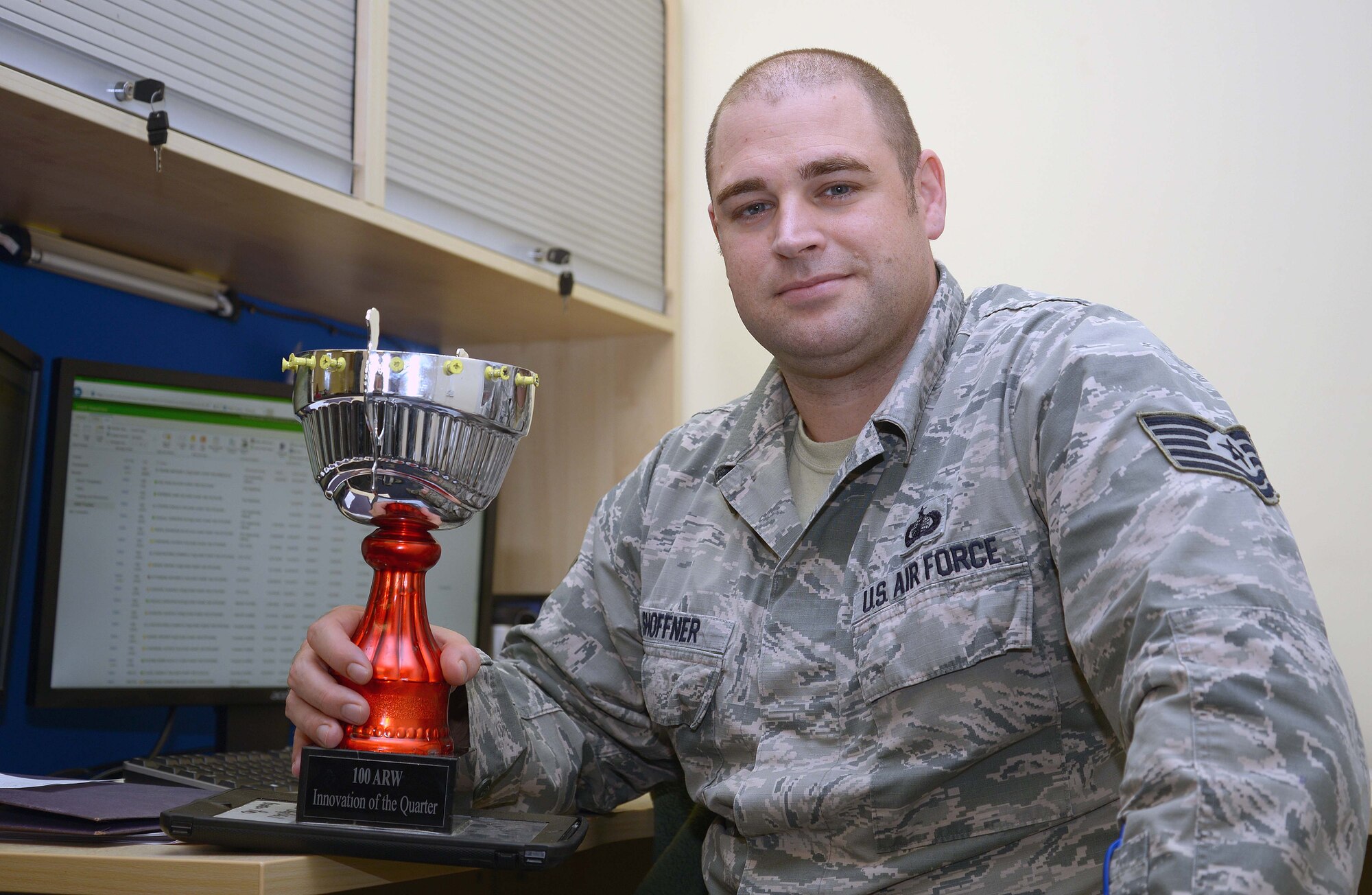 U.S. Air Force Tech. Sgt. Bruce Shoffner, 100th Comptroller Squadron quality assurance manager, sits with the Innovation of the Quarter trophy at RAF Mildenhall, England, Nov. 16, 2017. The trophy is comprised of different elements from each past innovation winner and will continue to be augmented by future winners. (U.S. Air Force photo by Airman 1st Class Benjamin Cooper)