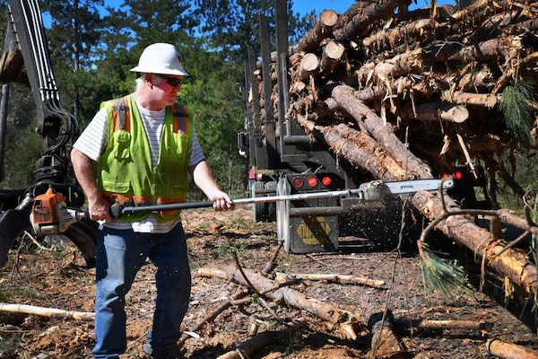 A contractor trims pine trees before transport to the lumber mill. The timber and agriculture program generates money that is used to fund the natural resource needs of the installation, a good by-product of proper resource management.