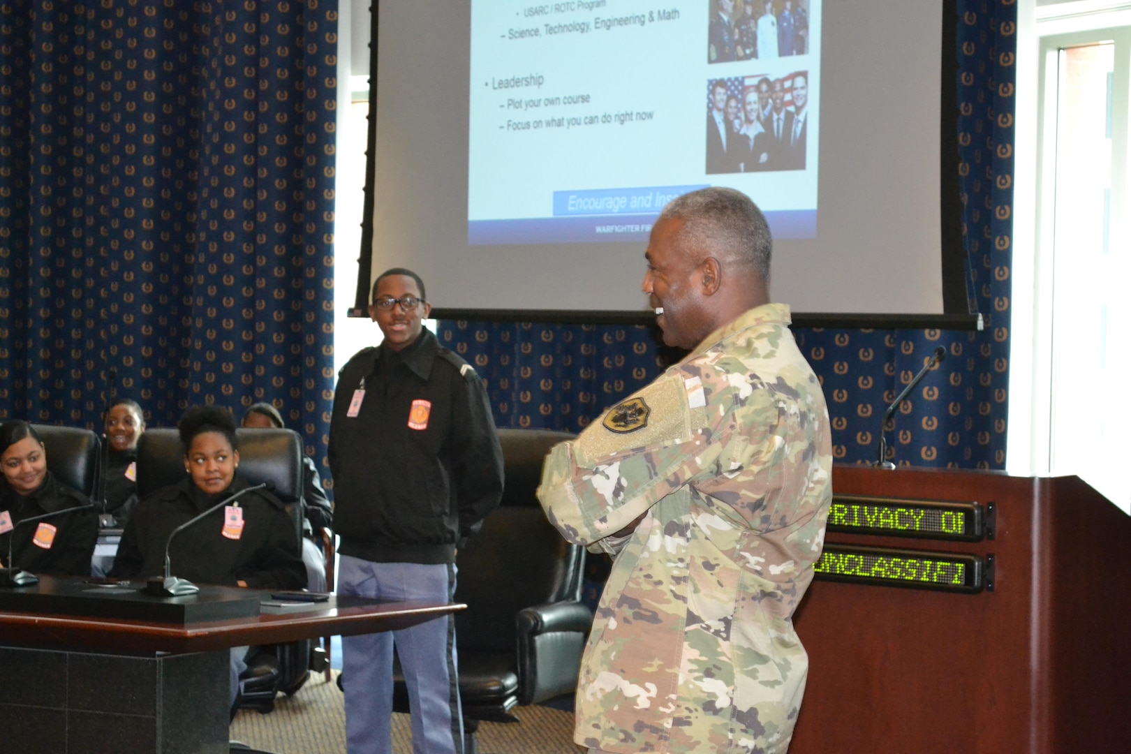 Army 3-star general in fatigues at right; JROTC students at left, in rear.