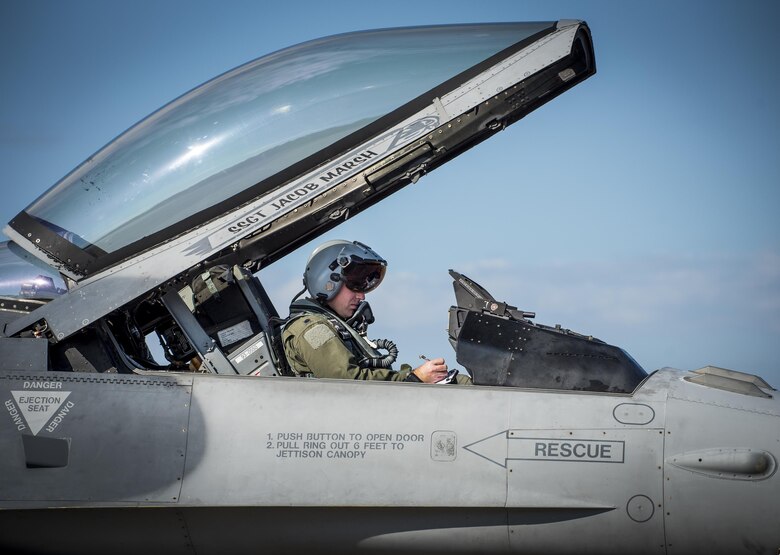 A 55th Fighter Squadron pilot from Shaw Air Force Base, S.C., makes notes in his F-16 Fighting Falcon prior to a Combat Hammer sortie Nov. 2, at Eglin AFB, Fla.  A-10s, F-16s, F-22s and MQ-9s visited the base to participate in the 53rd Wing exercise. The 86th Fighter Weapons Squadron’s Combat Hammer is a weapons system evaluation program for air-to-ground munitions. (U.S. Air Force photo/Samuel King Jr.)