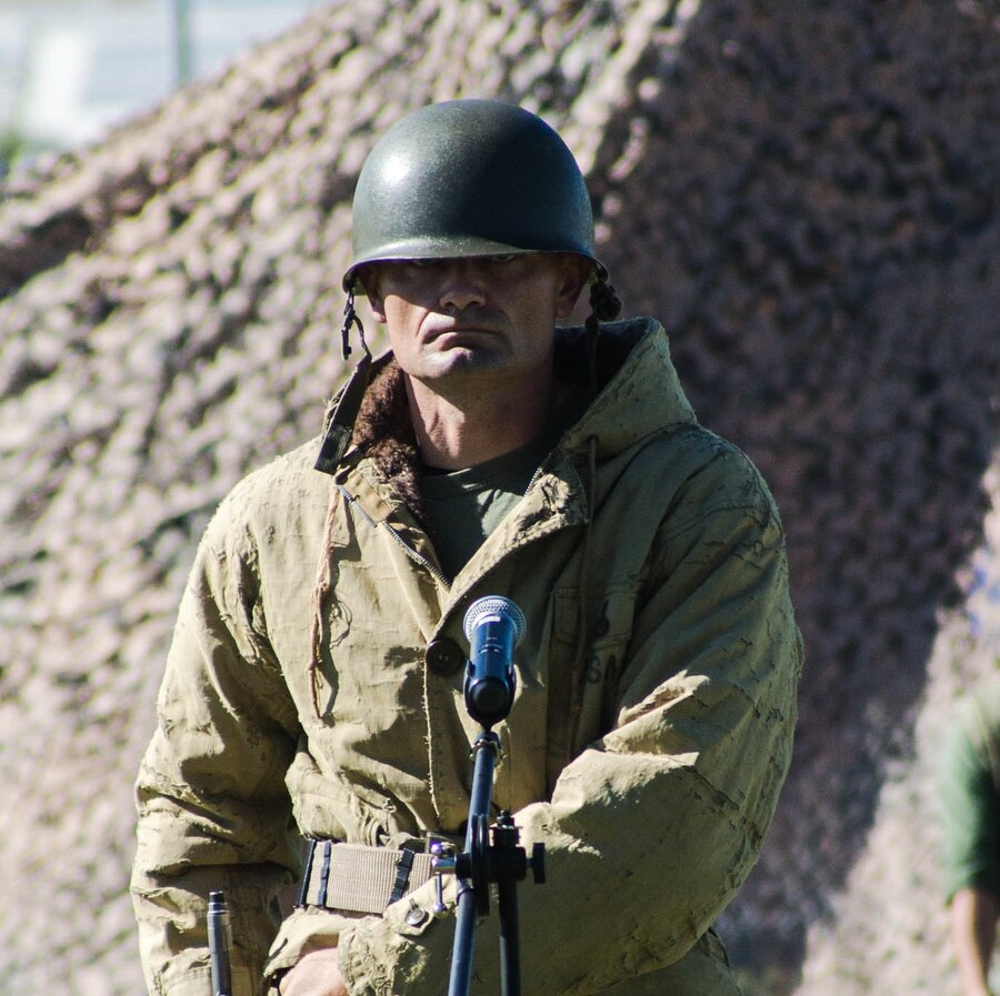 Staff Sgt. Andrew Minton-Smith, shop supervisor, Communications and Information Systems, dressed as a Korean War-era Marine, reads his lines at the Marine Corps Birthday Pageant, at Lance Cpl. Torrey L. Gray Field aboard the Marine Corps Air Ground Combat Center, Twentynine Palms, Calif., Nov. 08, 2017. The event included a historical uniform pageant and the traditional cake cutting ceremony in honor of the Marine Corps birthday. (U.S. Marine Corps photo by Pfc. William J. Chockey III)