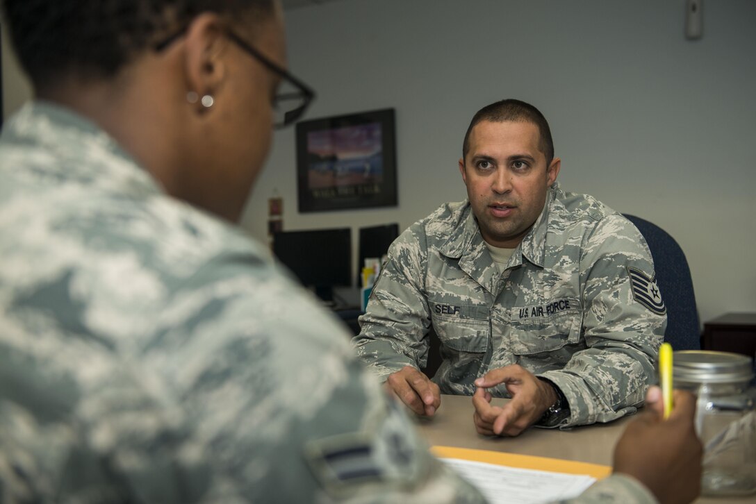U.S. Air Force Airman 1st Class Lakeia Garner, 20th Force Support Squadron outbound assignments personnel specialist, left, speaks with Tech. Sgt. William Self, 20th Aircraft Maintenance Squadron lead engine technician, about his orders at Shaw Air Force Base, South Carolina, Nov. 13, 2017.