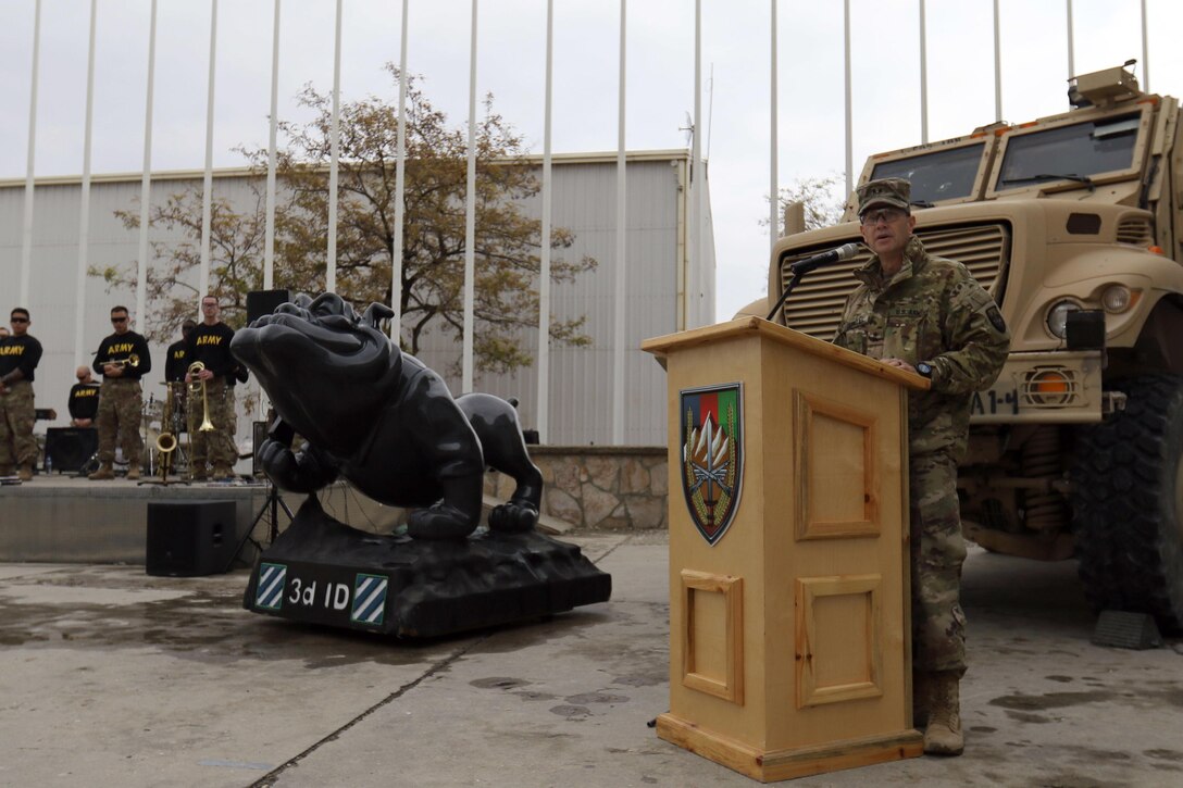 A senior officer speaks to troops from behind a podium.