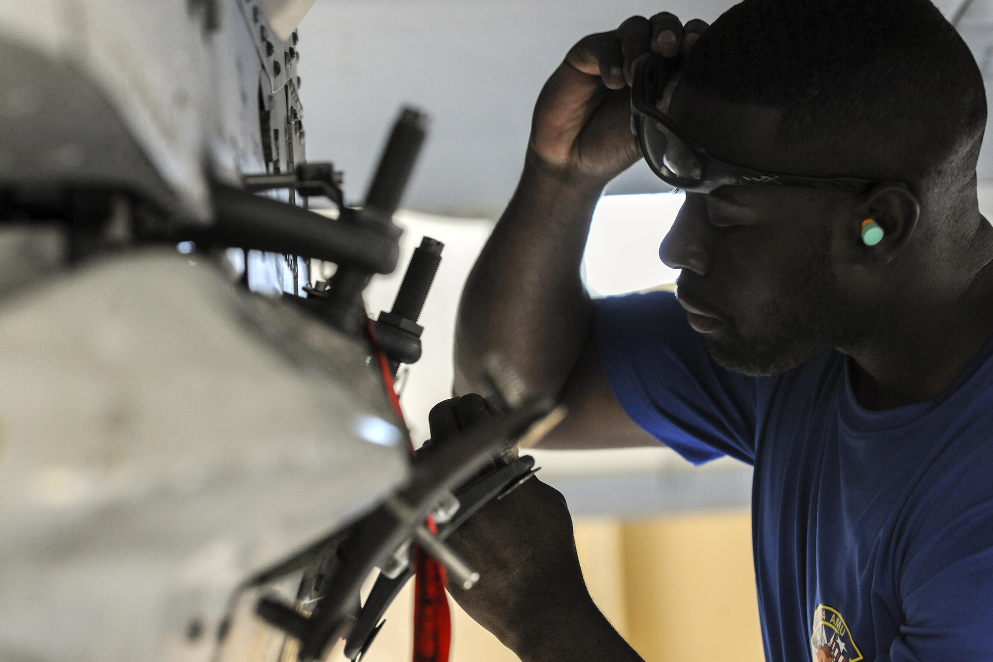Senior Airman Rodney Brown, 74th Aircraft Maintenance Unit weapons load crew member, examines a component on an A-10C Thunderbolt II during a quarterly weapons load competition, Nov. 16, 2017, at Moody Air Force Base, Ga. Judges evaluated the competitors based on dress and appearance, a knowledge exam and loading various munitions to determine the swiftest and most efficient load crew. (U.S. Air Force photo by Airman Eugene Oliver)