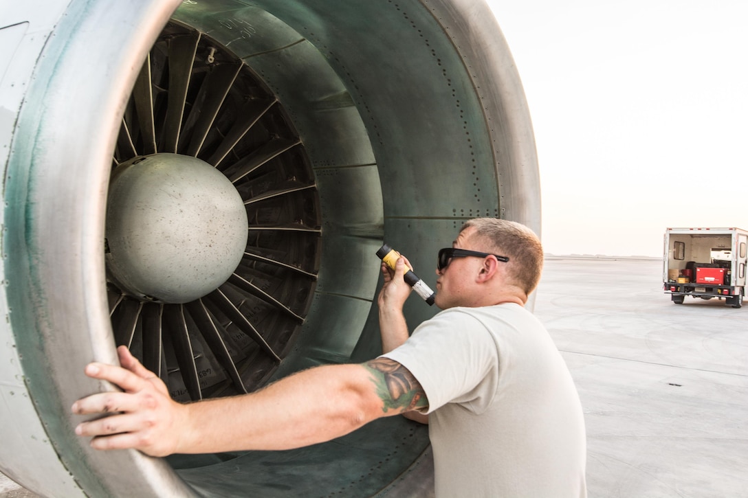 An airman performs a post-flight inspection of the intake and exhaust systems on an E-8C Joint Surveillance Target Attack Radar System.