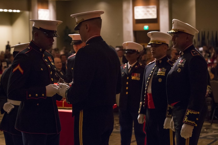 U.S. Marine Corps Lt. Col. Christopher J. Broadston, the oldest marine present, passes the second piece of cake to PFC. Lawrence A. Sivils Jr., the youngest marine present, as part of the ceremony for the Headquarters Battalion, Marine Corps Base Hawaii, 242nd Marine Corps Birthday Ball, at Hilton Hawaiian Village, Honolulu, Hawaii, Nov. 11, 2017. Each year Marines across the globe celebrate the date on which the Marine Corps was founded and the proud legacy that it's many years of existence has wrought. (U.S. Marine Corps photo by Sgt. Alex Kouns)