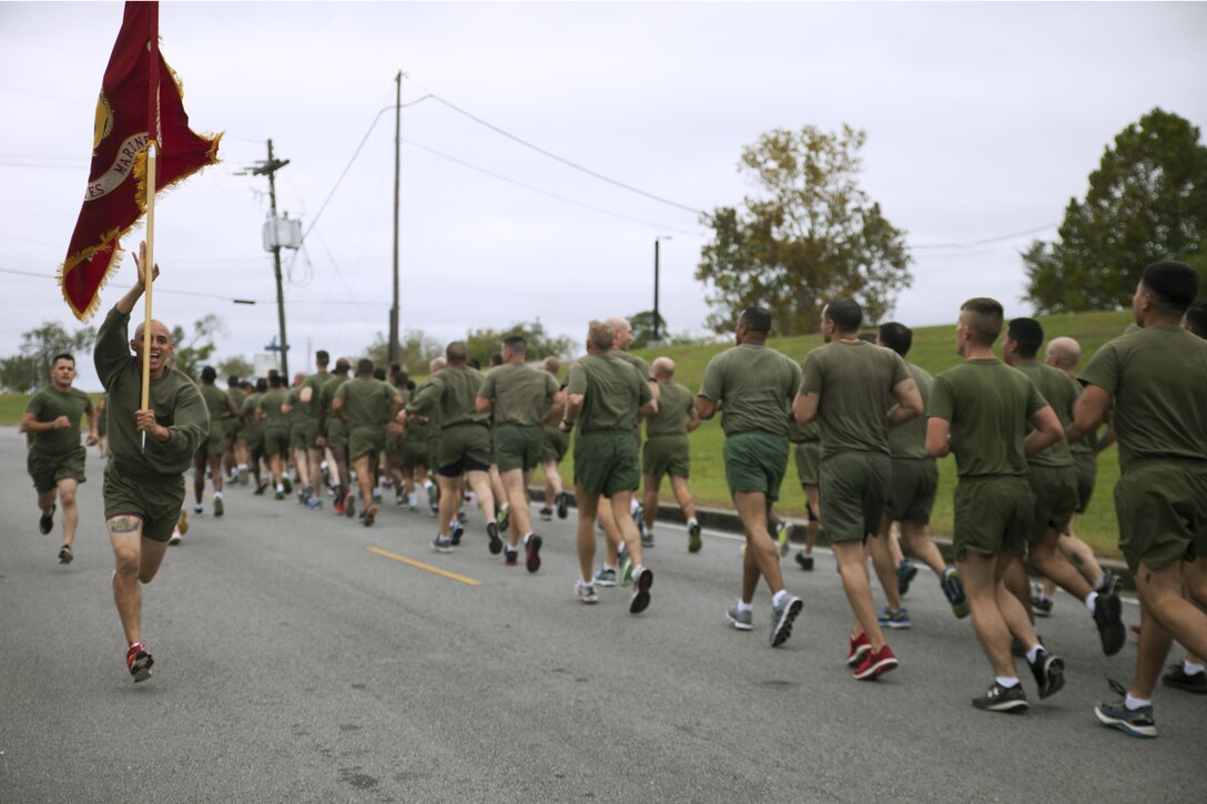 Cpl. Rosember Gloria, a maintenance data specialist with 4th Marine Aircraft Wing, Marine Forces Reserve, runs with a guide-on, alongside Marines from multiple MARFORRES units with Marine Corps Support Facility New Orleans, during a motivational run in New Orleans, Nov. 9, 2017.