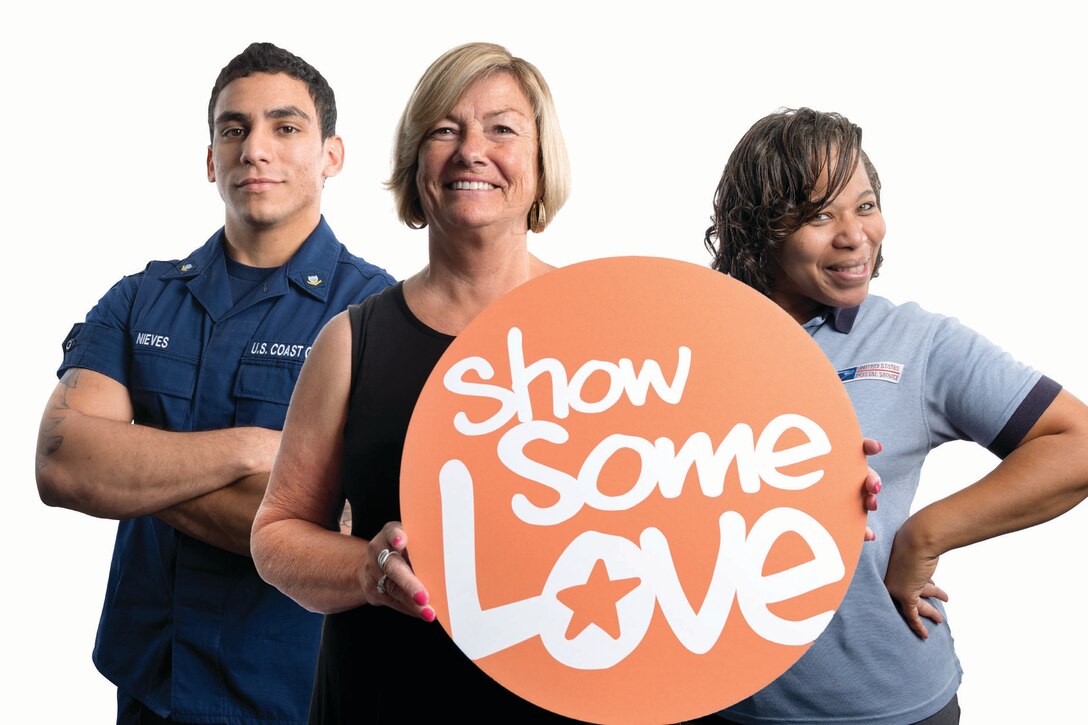 Three people pose for a photo with the "show some love" CFC sign.
