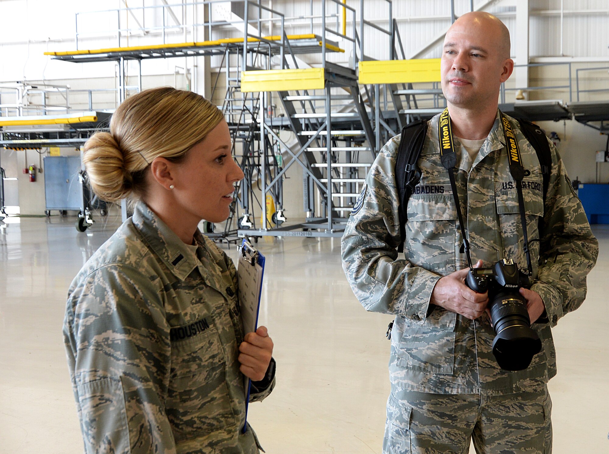 First Lt. Brianna Houston, 81st Training Wing Protocol Office chief of protocol, speaks to Tech. Sgt. Ryan Labadens, 403rd Wing Public Affairs photojournalist, about photos she is requesting of the 22nd Air Force change of command in the isochronal dock Nov. 14, 2017, on Keesler Air Force Base, Mississippi. The Protocol Office is in charge of ensuring every ceremony on Keesler goes to plan according to Air Force standards. (U.S. Air Force photo by Airman 1st Class Suzanna Plotnikov)