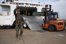 Lance Cpl. Antonio Diaz, a logistics embarkation specialist with Headquarters Company, Combat Logistics Regiment 3, directs forklifts with cargo onto a high-speed vessel, Nov. 13, 2017 at Pohang Port, South Korea. CLR-3 successfully completed a month-long deployment to South Korea for Exercise Winter Workhorse 17/ Korean Marine Exchange Program 18.1, which familiarizes the American armed forces with the Korean Peninsula and builds upon an enduring alliance between the two militaries. (U.S. Marine Corps photo by Sgt. Tiffany Edwards)